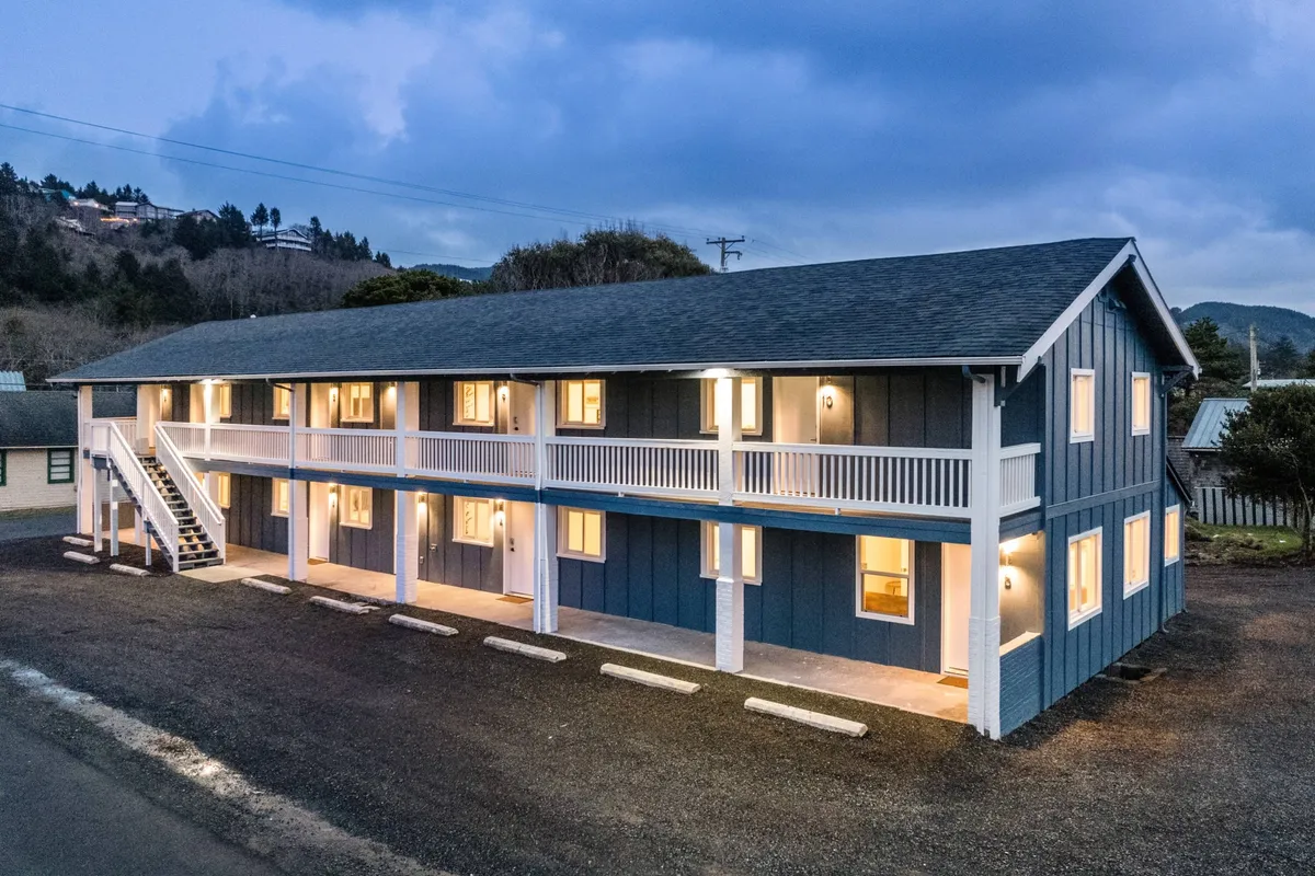 A welcoming exterior shot of the Inn’s blue facade, with warmly lit windows and a staircase leading to the upper floor. The image suggests comfort and sociability, with the possibility of enjoying sunsets or morning coffee on the balcony, and easy access to the area’s attractions.